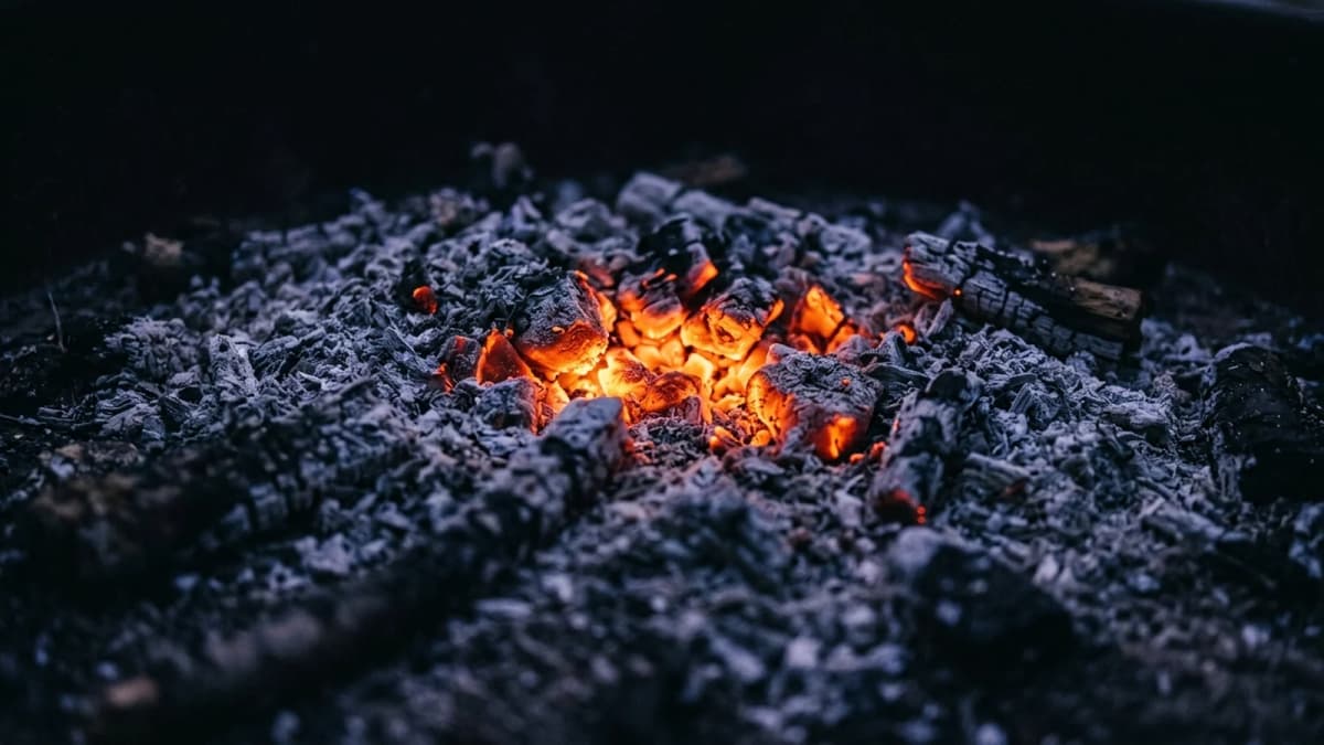 Orange embers glowing in a bed of grey ash